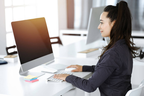 Geschäftsfrau mit Computer am Arbeitsplatz im sonnigen Büro. Arbeiten für Freude und Erfolg - Foto, Bild