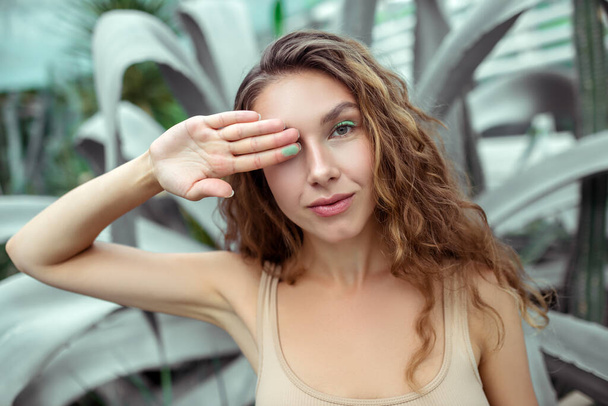 Pretty young woman closing one eye with her hand - Foto, afbeelding