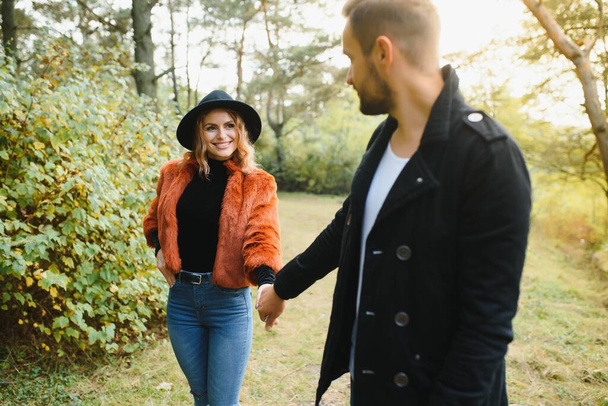 Lovers walking hand in hand in autumn park - Foto, imagen