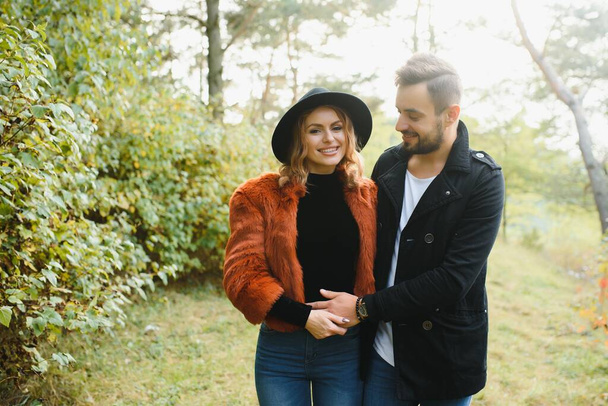 gentle and stylish couple are having a walk in the autumn park - Φωτογραφία, εικόνα