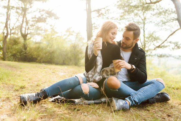 Casal apaixonado sentado no outono caído folhas em um parque, desfrutando de um belo dia de outono. - Foto, Imagem
