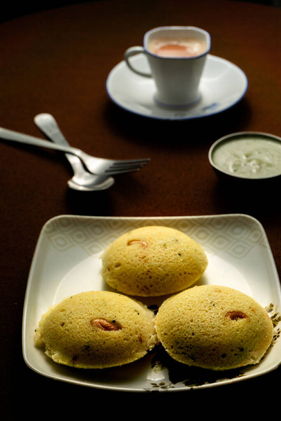 Deliciosa casa feita Rava idli com chutney e uma xícara de chá na mesa - Foto, Imagem