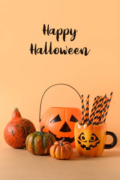 Halloween blank or invitation with party decorations, candy bowl, pumpkins, sweets, cute mug with drinking straw on orange background. Vertical composition with text - Happy Halloween. - Фото, изображение