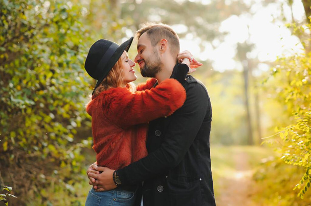 love, relationship, family, season and people concept - smiling couple hugging over autumn natural background - Fotoğraf, Görsel
