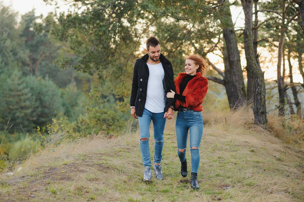 Lovers walking hand in hand in autumn park - Valokuva, kuva
