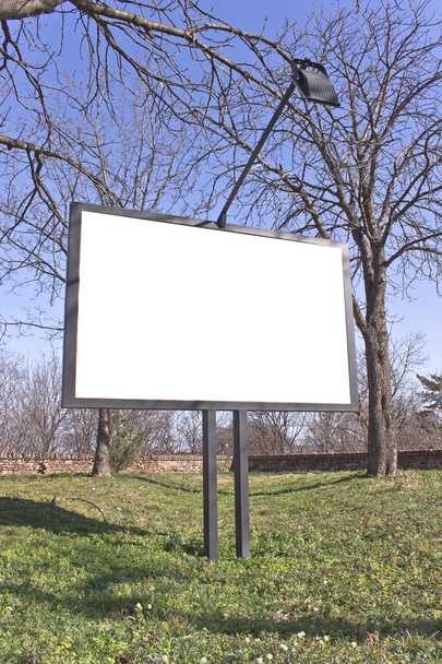 Порожній рекламний щит у парку з блакитним небом
 - Фото, зображення