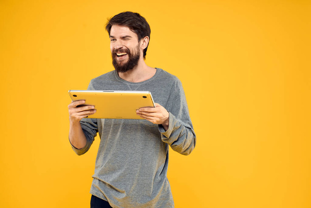 man with laptop wireless technology internet lifestyle work yellow isolated background - Foto, Imagen