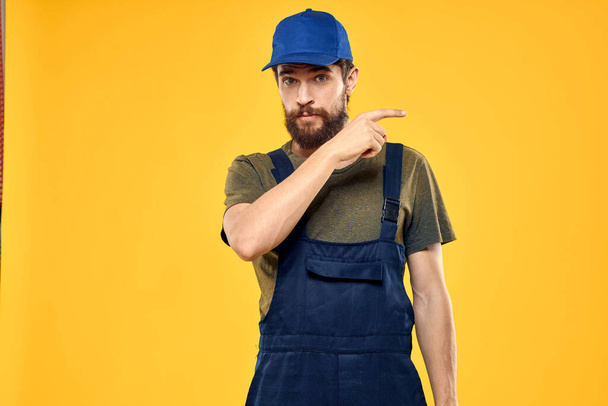 man in work uniform rendering service forklift work lifestyle yellow background - 写真・画像