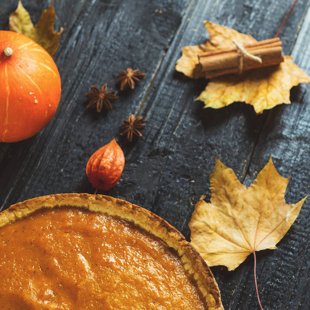 Pumpkin pie on a wooden table with ingredients and decor - Photo, Image