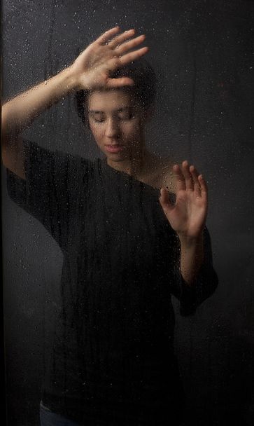Girl behind the wet glass - 写真・画像