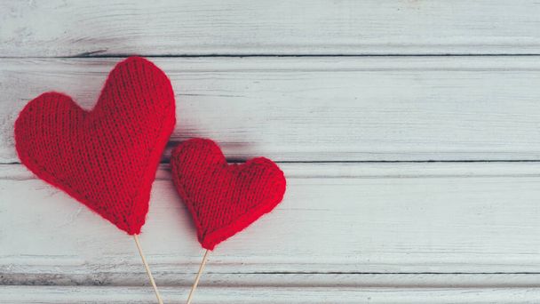δύο κόκκινες πλεκτές καρδιές σε ξύλινο φόντο. η έννοια της ημέρας του Αγίου Βαλεντίνου - Φωτογραφία, εικόνα
