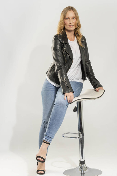 Блондинка молода жінка, одягнена в джинсовий одяг і блискавку шкіряну куртку
 - Фото, зображення