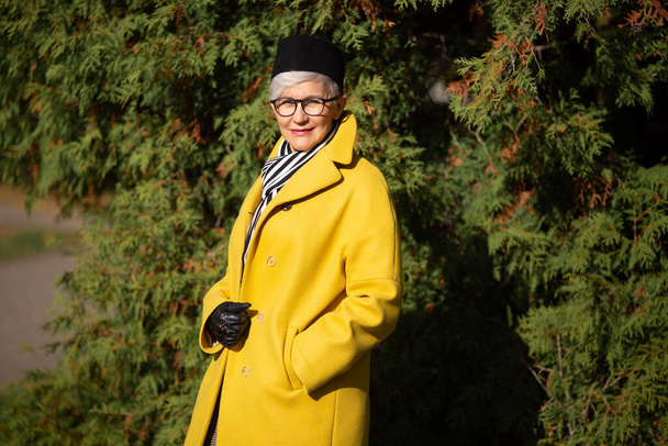 adult woman in yellow coat in the park in autumn - Foto, Bild