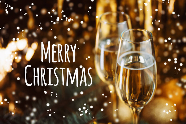Ποτήρια σαμπάνιας σε εορταστικό φόντο χρυσού. Χριστουγεννιάτικη κάρτα χαιρετισμού - Φωτογραφία, εικόνα