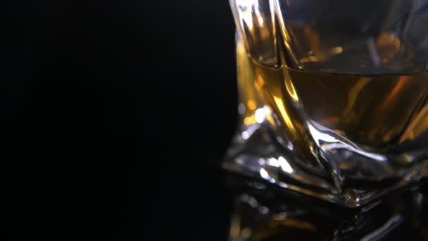 Chiudere su vetro bicchiere moderno riempito di whisky - Filmati, video