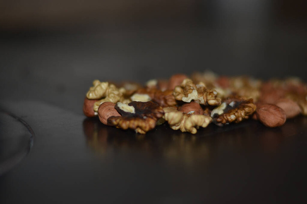 Assorted nuts on old kitchen. walnuts, hazelnuts, cashews, ... - Fotografie, Obrázek