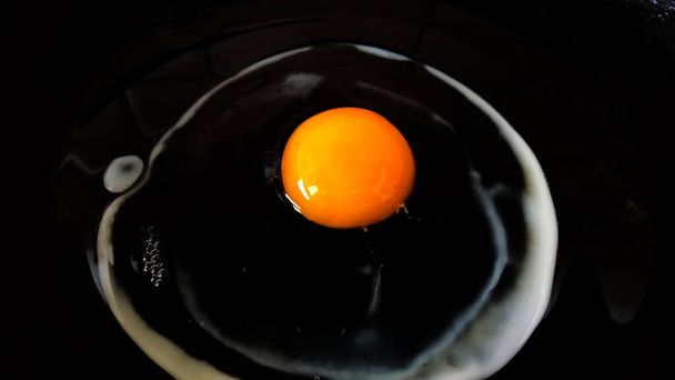 Raw egg in a cooking pan - 写真・画像