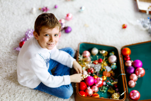 Beau garçon enfant et jouets de Noël vintage colorés et balle dans une vieille valise. Enfant décorant arbre de Noël - Photo, image