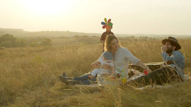 Parents jouant avec les enfants pendant le pique-nique sur le terrain - Photo, image