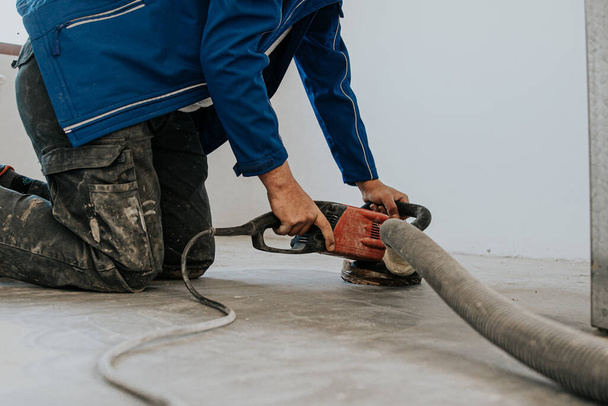 Rakennustyöntekijä käyttäen kone kiillotus pinta lattia tasoitus ja viimeistely kovetin tai epoksi betoni tehtaalla. - Valokuva, kuva
