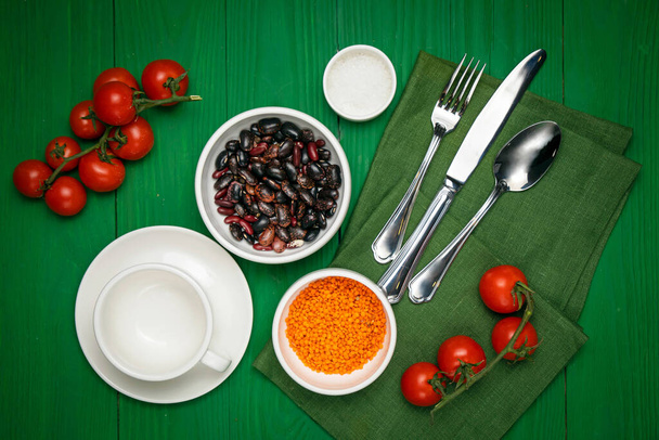 The dishes are laid out on a wooden table. Cherry, grass, utensils, sea salt - Fotografie, Obrázek