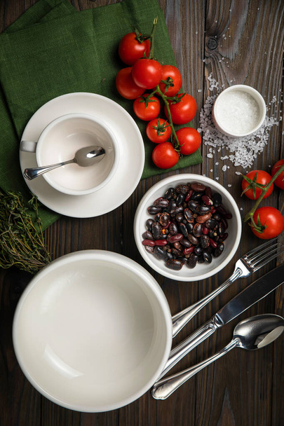 The dishes are laid out on a wooden table. Cherry, grass, utensils, sea salt - Fotografie, Obrázek