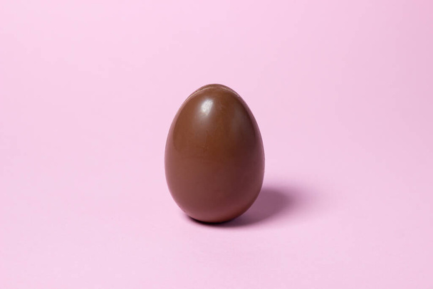 Chocolate egg on a pink background. Chocolate product - Φωτογραφία, εικόνα