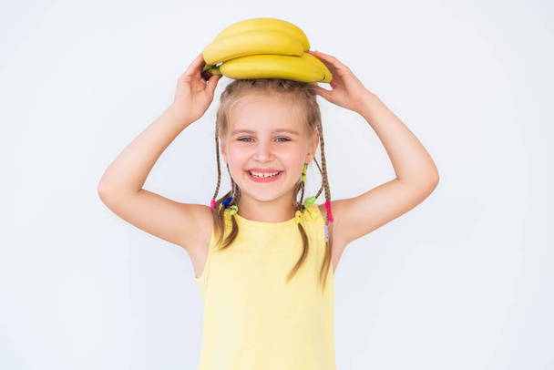 Kid girl with fine banana isolated on white - Foto, Imagen