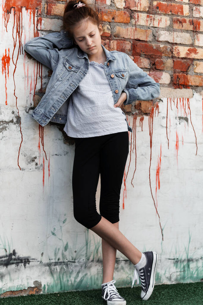 portrait of a beautiful teenage girl posing against a brick wall - Foto, Bild