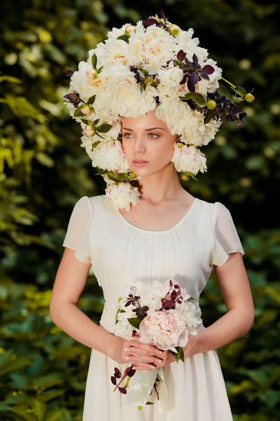 beautiful young girl with a cap of flowers on her head - Foto, afbeelding