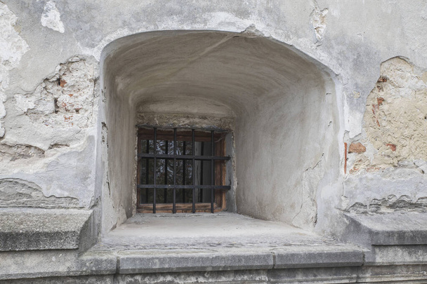 Παράθυρο με κάγκελα σε ένα παλιό εγκαταλελειμμένο φρούριο - Φωτογραφία, εικόνα