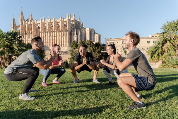 Spor yapan bir grup arkadaş şehir parkında spor yapıyor ve spor salonunda eğleniyorlar. - Fotoğraf, Görsel