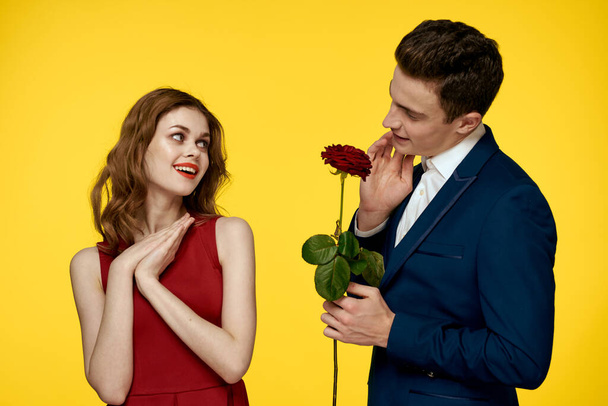 Lovers men woman with red rose in hands romance holidays yellow background family friends. - Photo, Image