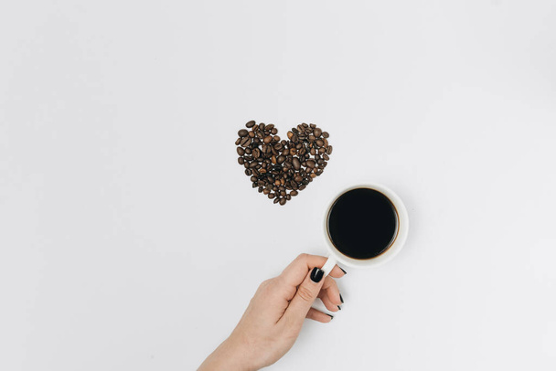 Mão feminina segurando xícara de café no fundo branco, espaço de cópia, tempo de relaxamento, bebidas quentes  - Foto, Imagem