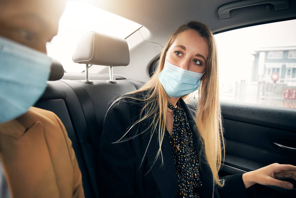 Pareja de negocios con máscaras conversando detrás del taxi durante la pandemia de salud - Foto, imagen