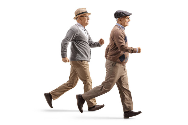 Two elderly men running isolated on white background - 写真・画像