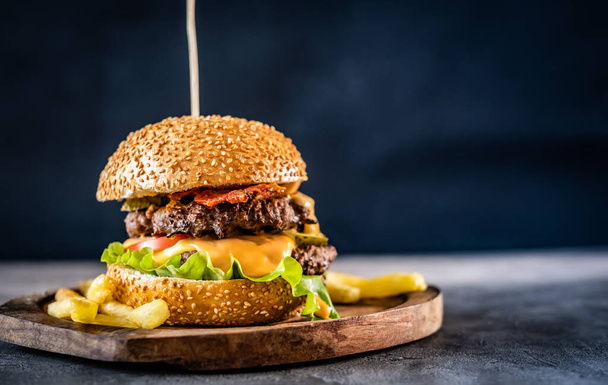 Appetizing burger on wooden board - Фото, изображение