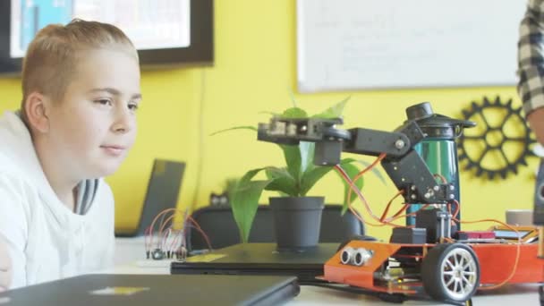 Teenager spielt im Unterricht mit Roboter - Filmmaterial, Video
