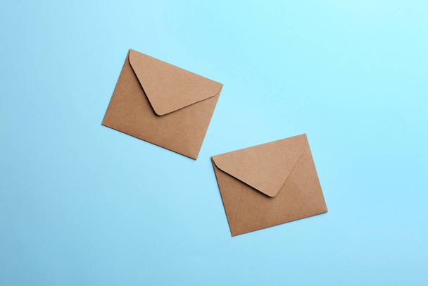 Brown paper envelopes on light blue background, flat lay - Zdjęcie, obraz