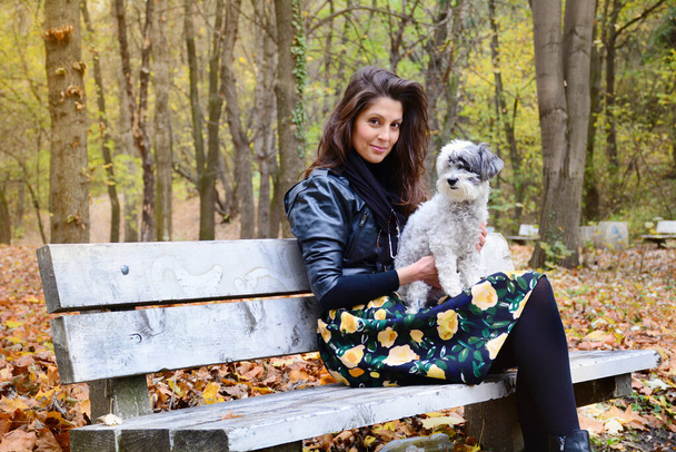 Beautiful Smiling Woman with her Dog in the Autumn Park .Pets and Happy Owner Outdoor in the Nature - Photo, Image