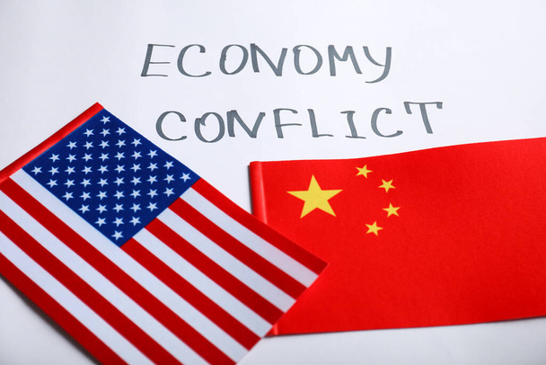 USA and China flags near words ECONOMY CONFLICT on white background - Zdjęcie, obraz
