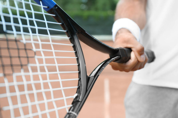 Sportsman with racket at tennis court, closeup - Fotoğraf, Görsel