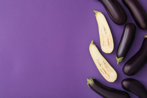 Raw ripe eggplants on violet background, flat lay. Space for text - Foto, Imagem