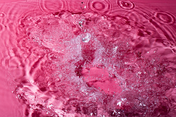 splash of water on a red background. Abstract wallpaper - Foto, Bild