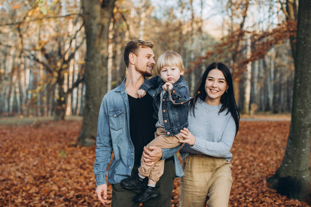 boldog család anya apa és baba őszi séta a parkban - Fotó, kép