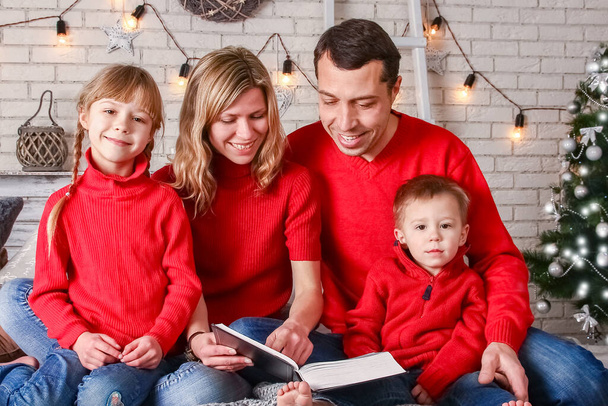 happy family reading a book at home at christmas - Zdjęcie, obraz
