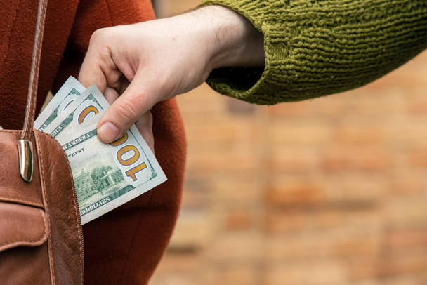 Misdaad zakkenrollen op straat geld dollars contant geld - Foto, afbeelding