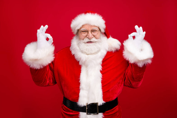 Photo of retired grandpa grey beard raise two hands show okey smile certain finish house decoration wear x-mas costume leather belt coat spectacles headwear isolated red color background - Φωτογραφία, εικόνα