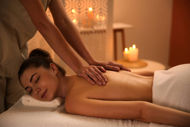 Young woman receiving back massage in spa salon - Foto, afbeelding