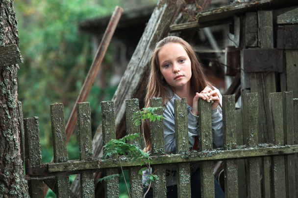 tiener meisje staan in de buurt vintage landelijk hek. - Foto, afbeelding